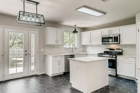 White kitchen with island refaced with a Qwikkit cabinet refacing kit